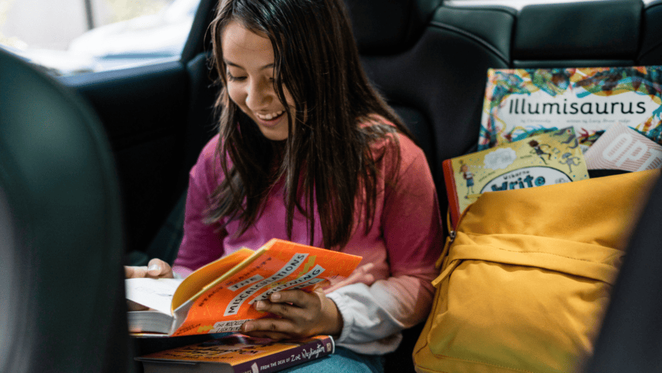 Young middle school girl is excited by new book she is reading on way to school.